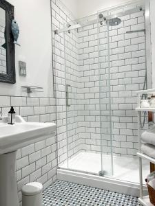 baño blanco con ducha y lavamanos en View at 142, en Mumbles