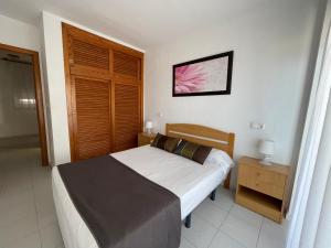 a bedroom with a bed and a wooden door at Palmera Beach in Pilar de la Horadada