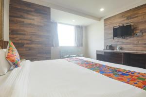1 dormitorio con 1 cama y TV en la pared en FabHotel Avasa Grand en Old Goa