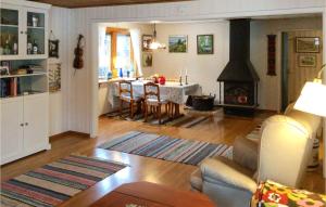 Awesome Home In Norrtlje With Wifi في نورتليه: غرفة معيشة مع طاولة ومدفأة