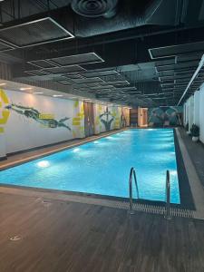 a large swimming pool with blue water in a building at Nuzul R154 - Elegant Apartment in Riyadh