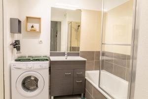 uma pequena casa de banho com uma máquina de lavar roupa e um lavatório em Le Beluga – Appartement proche Airbus em Colomiers