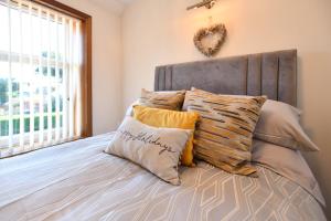 a bedroom with a bed with pillows and a headboard at The Lemon Tree in Prestwick
