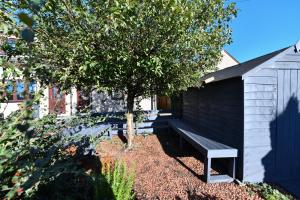 un banco junto a un árbol al lado de un edificio en The Lemon Tree en Prestwick