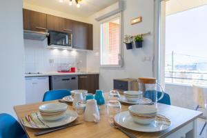 a kitchen with a wooden table with dishes on it at Le Beluga – Appartement proche Airbus in Colomiers