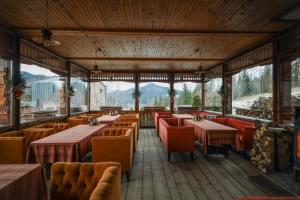 restauracja ze stołami i krzesłami oraz górami w tle w obiekcie Korunka w mieście Tatarów