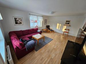 Romme stugby في بورلانغ: غرفة معيشة مع أريكة حمراء وطاولة