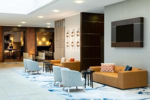a lobby with couches and chairs and a television at Courtyard by Marriott Bremen in Bremen