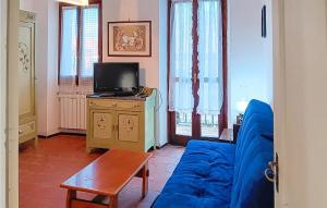 sala de estar con sofá azul y TV en Pet Friendly Apartment In Vignale Monferrato With Kitchen en Vignale Monferrato