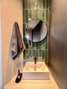 W łazience znajduje się biała umywalka i lustro. w obiekcie Highland Gate Range View w mieście Dullstroom