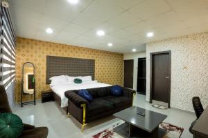 a bedroom with a bed and a couch in a room at VIDDOSH RESIDENCE in Ibadan