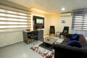 a living room with a couch and a desk at VIDDOSH RESIDENCE in Ibadan