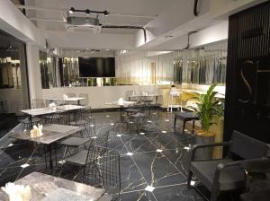 a restaurant with tables and chairs and a flat screen tv at Shelton Airport Hotel in Arnavutköy