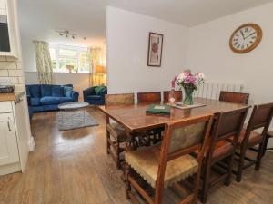 a kitchen and living room with a table and chairs at Aldrich Cottage in Kilmersdon
