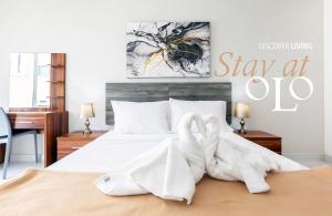 um quarto com uma cama com toalhas brancas em Studio Penthouse with kitchenette and side seaview at the new Olo living em Paceville