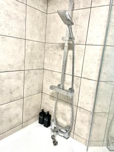 y baño con ducha con cabezal de ducha. en Central 4 bedroom house in the heart of Birmingham city with Free Parking, and sleeps up to 8!, en Birmingham