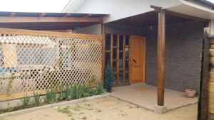 une véranda couverte d'une maison avec une porte en bois dans l'établissement Cabaña #2 "A Pies del Valle", à Limache