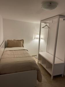 Medea Home في Carosino: غرفة نوم بيضاء مع سرير ورف