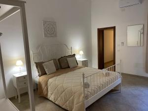 Medea Home في Carosino: غرفة نوم بسرير وطاولتين ومرآة