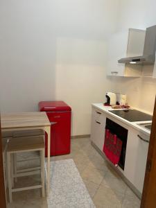una cucina con frigorifero rosso e tavolo di Medea Home a Carosino