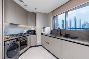 een keuken met een wastafel en een vaatwasser bij Waves Holiday Homes - 15 Northside, Tower 1, Two Bedroom in Dubai