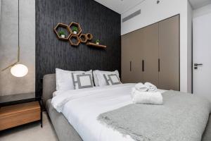 een slaapkamer met een groot wit bed en handdoeken bij Waves Holiday Homes - 15 Northside, Tower 1, Two Bedroom in Dubai
