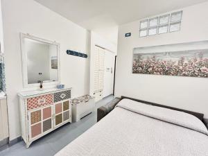 a white bedroom with a bed and a mirror at Residence Annunziata in Gaeta