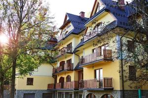 een geel gebouw met balkons aan de zijkant bij Apartament Cappuccino&Bambusowy in Zakopane