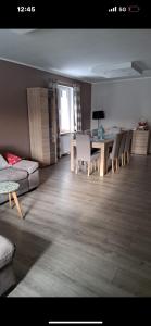 a living room with a table and chairs and a couch at Przytulny in Łęczyca +5 photos
