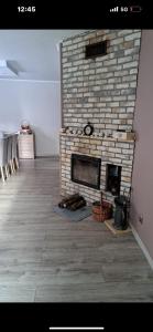 a living room with a brick fireplace in a room at Przytulny 