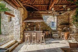 a bar in a stone building with stools at Caserio La Corredoira - Villa de lujo en Armeirín in Cobre