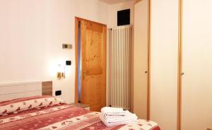 - une petite chambre avec un lit et une porte dans l'établissement Casa Lastei, à Pozza di Fassa