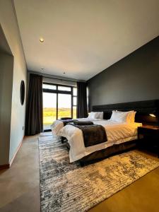 1 dormitorio con 2 camas y ventana grande en Highland Gate Range View en Dullstroom