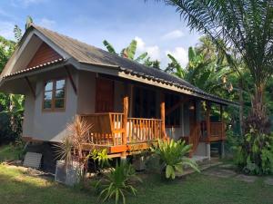 a small house with a balcony in a garden at Anattaya Holiday Home in Ko Yao Noi