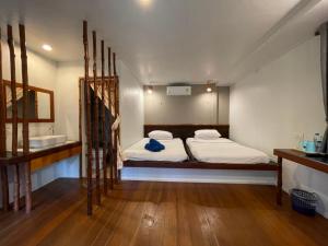 1 dormitorio con 2 camas y lavamanos. en Anattaya Holiday Home, en Ko Yao Noi