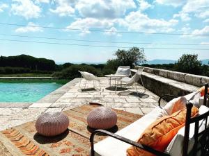 eine Terrasse mit Stühlen, einem Tisch und Wasser in der Unterkunft Pavillon Torre Del Falco in Ronciglione