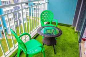 two green chairs and a table on a balcony at LUXURY C44 in Nairobi