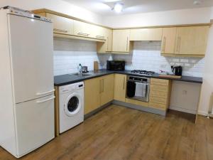 a kitchen with a white refrigerator and a dishwasher at Fabulous 2 bed apt 10 mins from City Centre in Glasgow