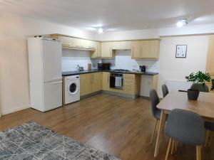 a kitchen with a white refrigerator and a table at Fabulous 2 bed apt 10 mins from City Centre in Glasgow