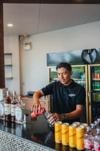 um homem parado atrás de um balcão numa cozinha em Chill Inn Samui Hostel and Restaurant em Koh Samui 