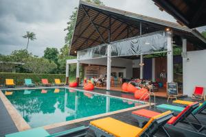 a swimming pool with chairs and people sitting around it at Chill Inn Samui Hostel and Restaurant in Koh Samui 