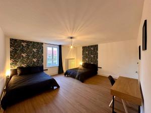 een woonkamer met 2 bedden en een tafel bij L'Atelier loft in Foucherans
