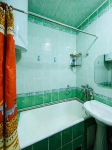 a bathroom with a bath tub and a sink at 2 комнатная уютная квартира в 18 мкрн in Shymkent