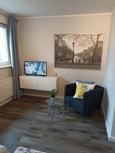 - un salon avec un canapé et une télévision dans l'établissement Ferienwohnung Adriane, à Nordhorn