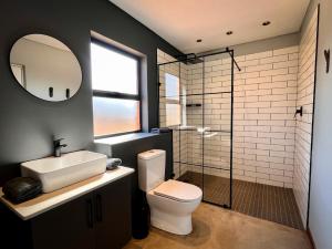 W łazience znajduje się toaleta, umywalka i lustro. w obiekcie Highland Gate Range View w mieście Dullstroom