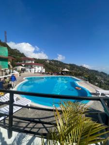 vistas a la piscina desde el balcón de un complejo en Nagarkot Resort PVt. Ltd, en Nagarkot
