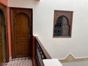 eine Treppe mit einer Holztür und einem Fenster in der Unterkunft RIAD LAICHI in Marrakesch