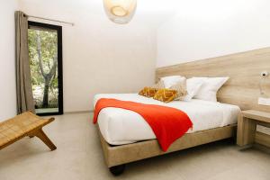 a bedroom with a bed with a red blanket at Les villas de Bagheera, oasis naturiste in Linguizzetta +89 photos