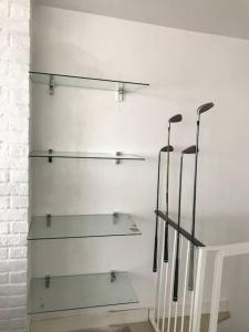 two glass shelves on a wall with baseball bats at Trastevere Attic Raffaello’s rooms in Rome