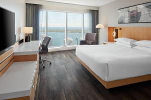 a hotel room with a bed and a large window at Delta Hotels by Marriott Toronto in Toronto